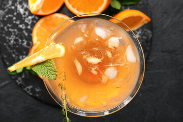 Glass of tasty Tequila Sunrise cocktail on black background