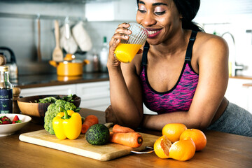 Black woman is drinking orange juice