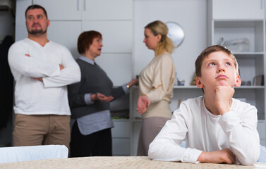 Fototapeta na wymiar Sad desperate little boy during parents quarrel in home interior.
