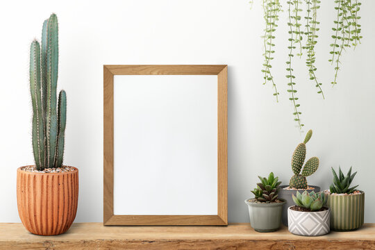 Wooden picture frame on a shelf with cactus