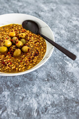 vegan spicy barley with olives and chilli flkes topping, healthy plant-based food
