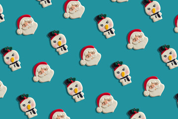 christmas cookie pattern in the shape of santa claus and snowmen, on a blue background