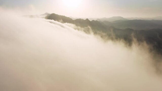 Soaring in clouds like bird. Flying fast in clouds view from cockpit window. The clouds are moving on camera with golden cinematic sunset on background. Timelapse through the cloudscape in mountains