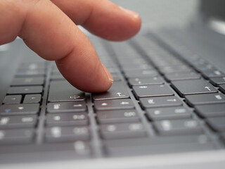 Closeup shot of a person typing on a notebook keyboard