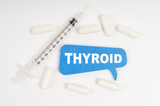 On a white background pills, a syringe and a blue plate with the inscription - THYROID