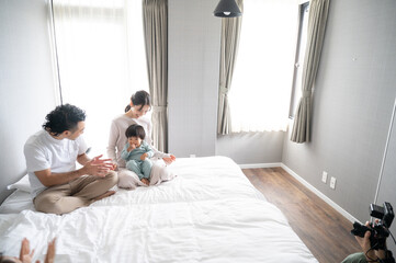 休日に子どもをあやす素敵なパパさんと美しいママ1...