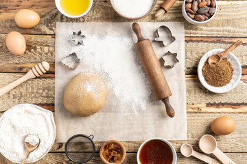 Frame of Ingredients for cooking Christmas baking and gingerbread cookies on a wooden background, top view. New Year, holidays