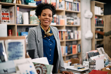 Portrait of happy black woman working in bookstore and looking at camera. - Powered by Adobe