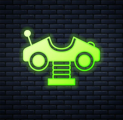 Glowing neon Swing car on the playground icon isolated on brick wall background. Childrens carousel with car. Amusement icon. Vector