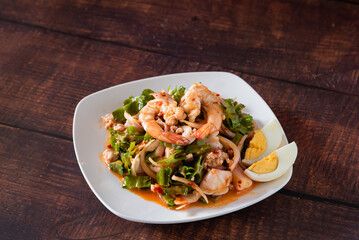 Traditional Thai salad shrimp, vegetable and egg on wooden background