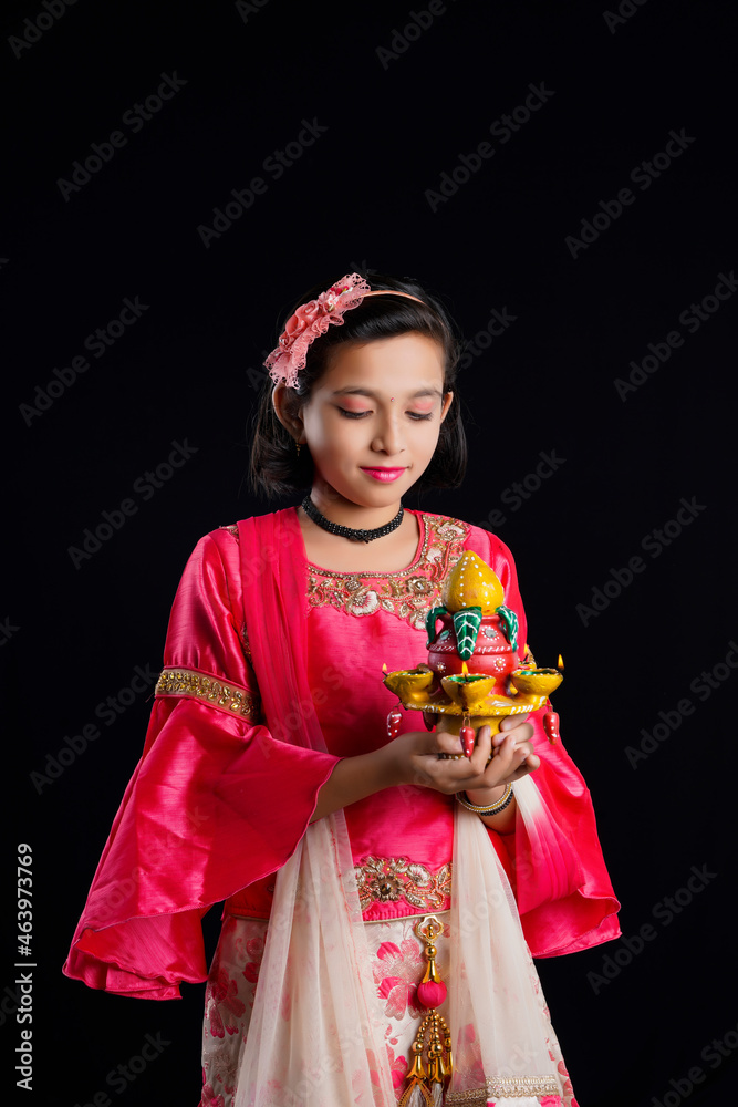 Poster Cute Indian little girl holding diya or oil lamps for Diwali Celebration.