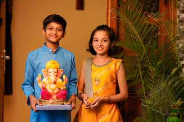 Little indian siblings with lord ganesha.