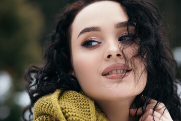 Pretty woman smile stand outside street snow сold park forest weather winter holiday New Year Christmas dressed knitted warm sweater and scarf, blue eyes copy space blurred bokeh background.
