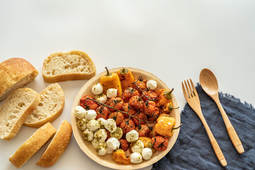 Italian bread Ciabatta, grilled vegetables, mozzarella balls, wooden cutlery on white background. Rustic lunch ideas.