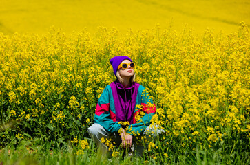 Stylish girl in 90s tracksuit in rapeseed field - 463977727