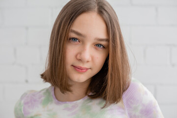 Face of a teenage girl in close up. Teen with problematic skin. Girl with a square hairstyle. Acne and scars. Natural portrait. No makeup and retouch. High quality photo