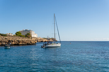 General view of turquoise waters on the island of Mallorca, with a yacht anchored in the sea. Cala Marsal beach, Mallorca island, Spain