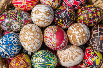 Fototapeta na wymiar Many bright and colorful easter eggs in a wicker basket, close up