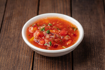 Small bowl of appetizing salsa sauce on wooden background