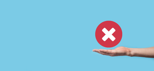 Hand holds icon,cancellation symbol,cancel icon.Cross mark flat red icon.round X mark.cancel button.Wrong.cross mark rejection.Declined.On dark background.Banner.Copy space.Place for text.