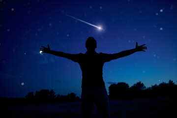 Fototapeta na wymiar Silhouette of a man enjoying countryside under the starry skies.
