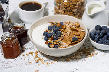 bowl of healthy wholegrain flakes, yogurt and fresh blueberries for breakfast
