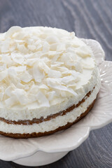 chocolate cake with coconut cream on a dark background, vertical