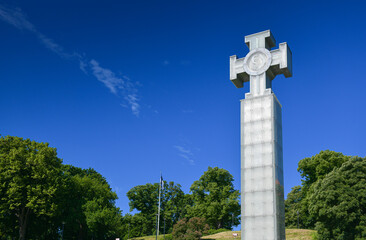 The War of Independence Victory Column landmark in Tallinn, Estonia, on a blue sky background.