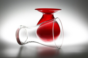 Composizione in controluce con due vasi in vetro, uno rosso e uno trasparente