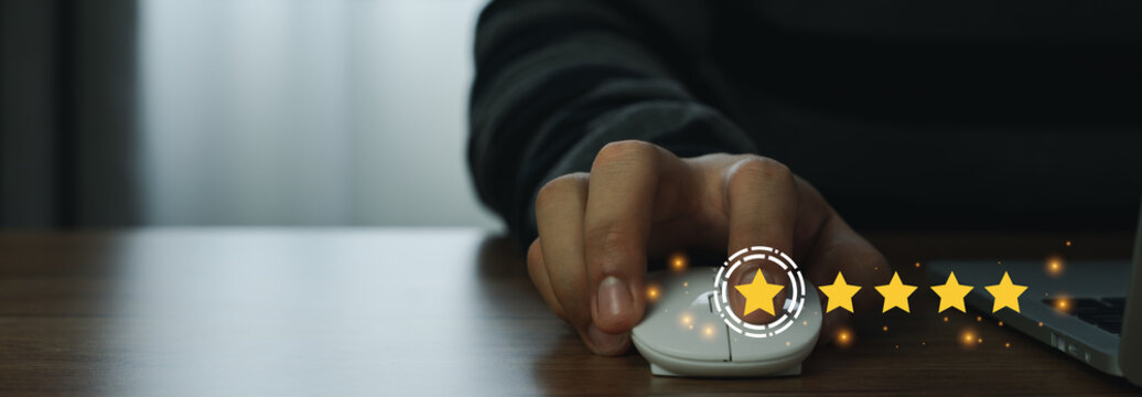 Close up man using mount computer for rating feedback from customer service with annual survey with five gold star icon. Business annual satisfaction survey concept. User reviews and feedback online.