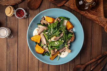 Bowl of healthy beef salad with potato and spinach on wooden background