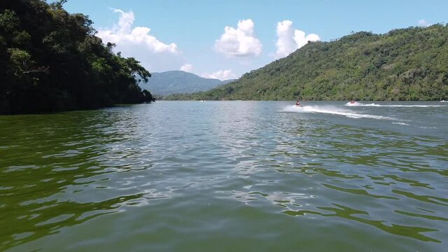 people doing sports with jet ski in La Laguna Azul in Peru. Drone shot near water. Lake in the peruvian jungle. Amazonas