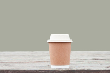 a cup of coffee on a gray background. tea party concept. paper cup on the table