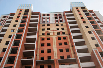 City house under construction. Unfinished multi-storey building. Uncovered facade of the building....