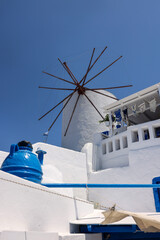 Obraz premium Traditional white windmill in Oia on the island of Santorini. Cyclades, Greece