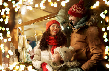 family, winter holidays and celebration concept - happy mother, father and little daughter at...