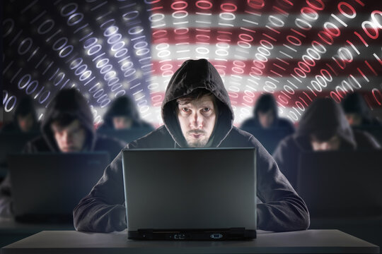 Many American hackers in troll farm. USA flag in background. Internet security concept.
