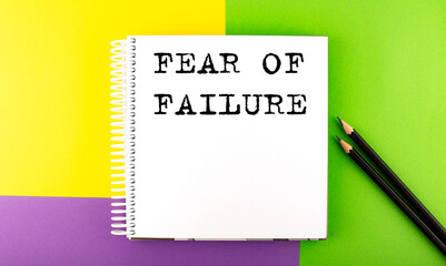 Minimal work space : sketchbook on the colorful background with FEAR OF FAILURE text