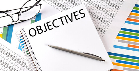 Notebook with text OBJECTIVES . Diagram and white background,Business concept