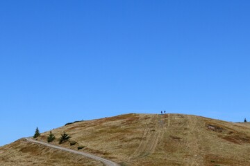 landscape with blue sky and people walking in the mountains