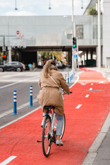 traffic, city transport and people concept - woman cycling along red bike lane with signs of bicycles and two way arrows on street in tallinn, estonia