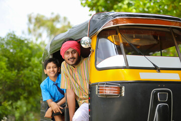 Indian auto rikshaw or tuk tuk driver with his schoolboy