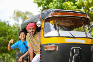 Indian auto rikshaw or tuk tuk driver with his schoolboy