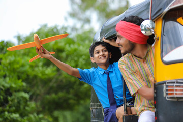 Indian auto rikshaw or tuk tuk driver with his schoolboy