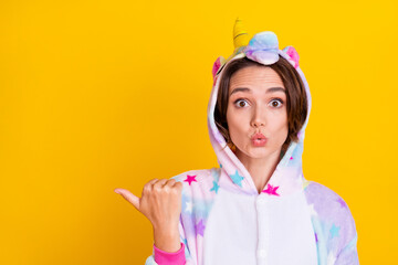 Photo portrait woman in costume pointing copyspace thumb amazed isolated vivid yellow color background
