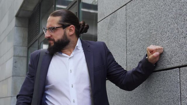 Furious bearded man looser beating wall with fist, fail agreement with investors