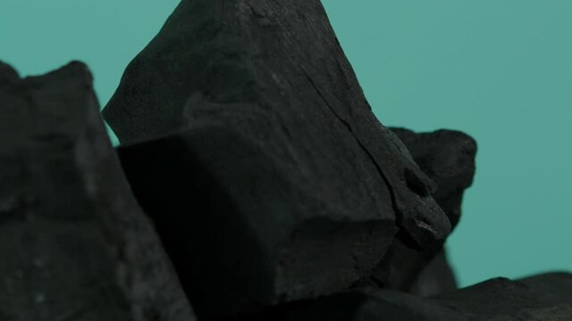 Wood charcoal. Black Charcoal on Blue green screen background. Used for cooking grill or industries. Natural wood charcoal. Black carbon reesidue produced by strongly heating wood. for grilled BBQ. 