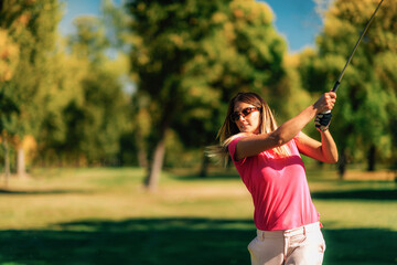 Woman playing golf on a beautiful sunny day