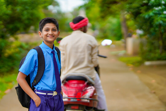 Young Indian Farmer Dropping His Child To School On Bike