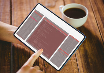 Hands of caucasian female programmer with coffee using tablet with coding on screen